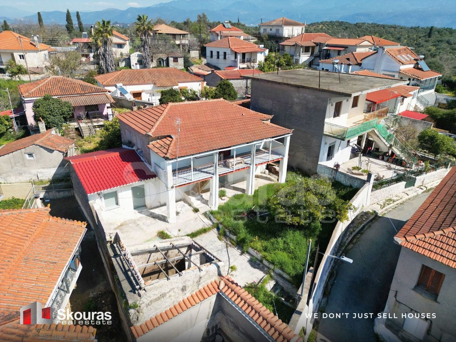 Two-storey stone house for sale in Ammos, Messinia, with a covered veranda and mountain views