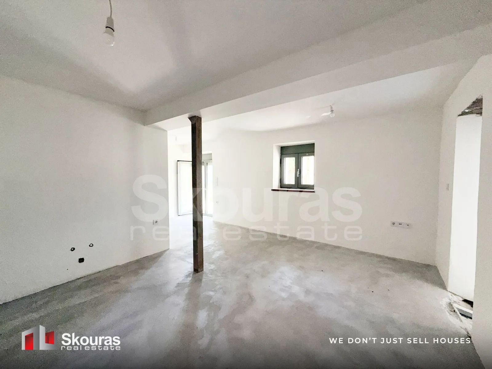 Ground-floor room with a new aluminium window in the Ammos house